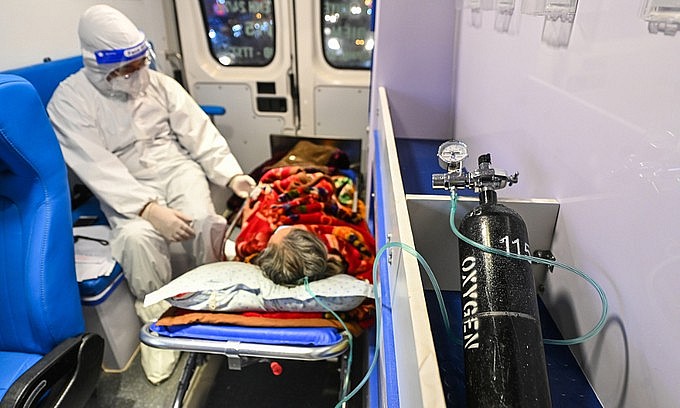 A medical staff takes care of a Covid-19 patient on an ambulance in Hanoi on December 29, 2021. Photo: VnExpress