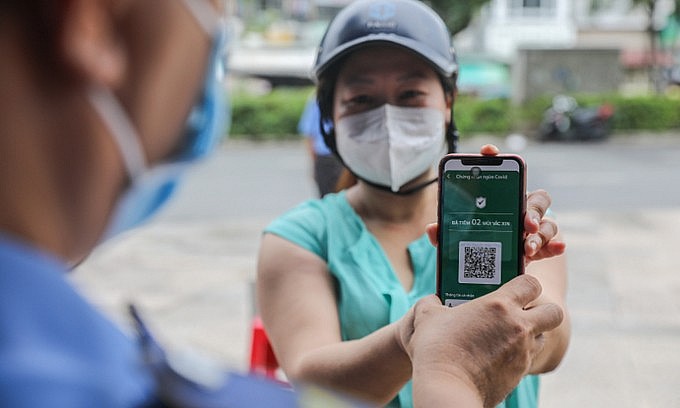 A woman shows her vaccine status to a security guard at a supermarket in Ho Chi Minh City on October 6, 2021. Photo: VnExpress
