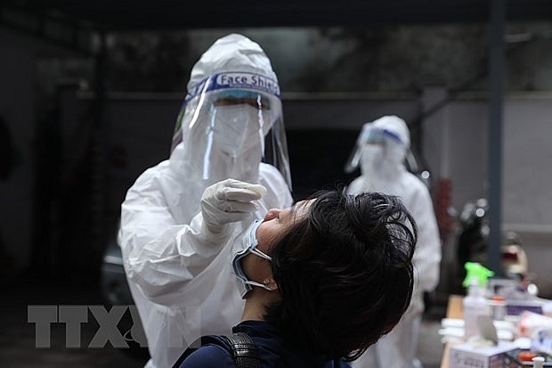 A health worker takes a nasal swab for Covid-19 testing. Photo: VNA