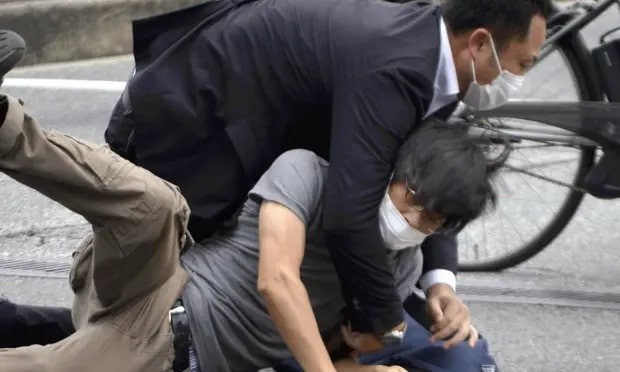 Tetsuya Yamagami (bottom) is arrested after the shooting. Photograph: Katsuhiko Hirano/AP