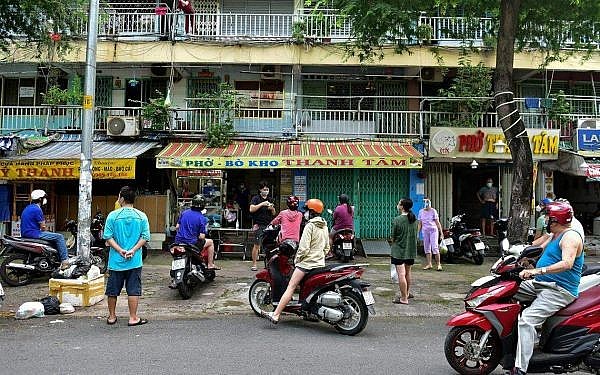 Residents observing social distancing while waiting outside a take-away eatery in Ho Chi Minh City last October, following the easing of strict Covid-19 coronavirus curbs that had been in place for the preceding 3 months.PHOTO: AFP