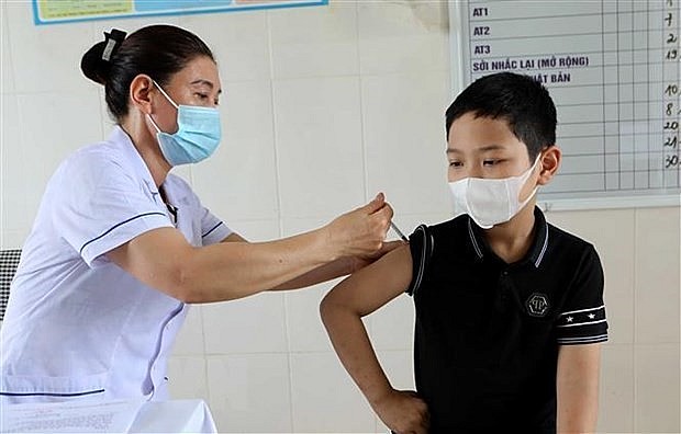 A boy gets vaccinated against Covid-19. Photo: VNA