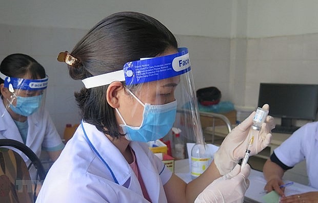 A health worker prepares to administer Covid-19 vaccine. Photo: VNA
