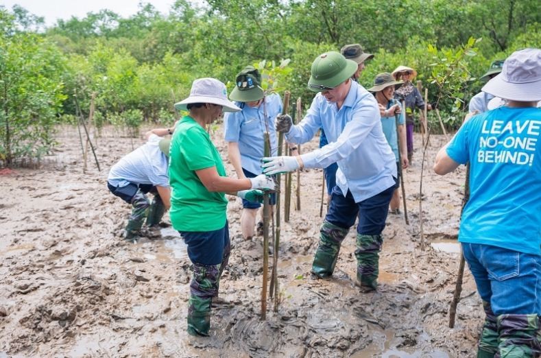 UN Assistant Secretary General and UNDP Regional Director for Asia and the Pacific Kanni Wignaraja joins local leaders and people in planting mangrove forests, one of the most effective nature-based solutions to enhance the resilience of coastal communities to climate change. Source: baoxaydung.com.vn