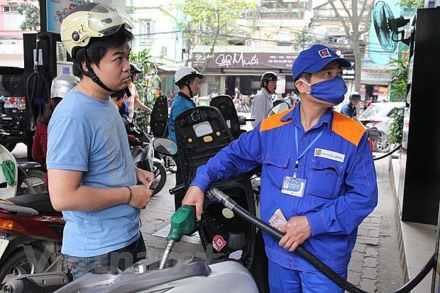 A driver gets his motorbike refilled at a fuel station. Photo: VNA