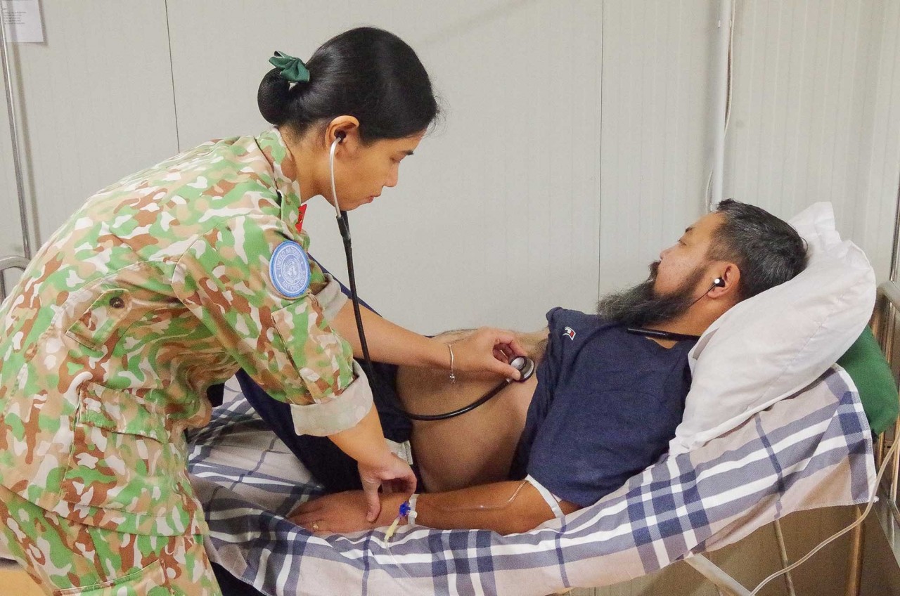 Vietnamese blue-beret doctor examines Mongolian patient who suffered acute pancreatitis. Photo: BVDC 2.4