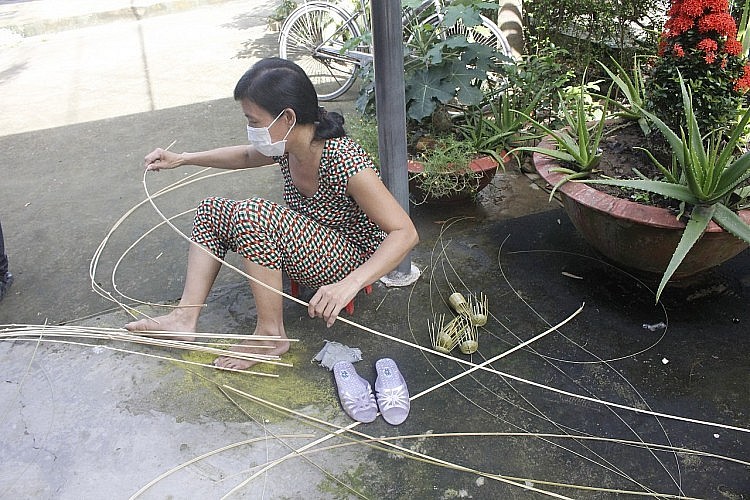 Duong Thi Tien (Giong Dinh hamlet, Dai An commune, Tra Cu district, Tra Vinh) takes advantage of her free time to knit handicrafts.