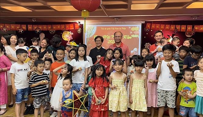Ambassador Dinh Toan Thang and his wife gave gifts and took souvenir photos with the children of staff of the Embassy and Vietnamese representative agencies in France.  Photo: VNA