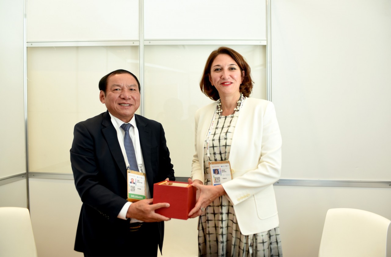 Minister Nguyen Van Hung presents souvenirs to UNESCO Chairperson of the Executive Board Tamara Rastovac Siamashvili.