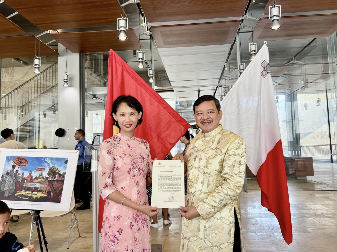 A representative of Vietnamese Embassy in Italy and Malta hands over a congratulatory letter from Deputy Foreign Minister Pham Quang Hieu to Nguyen Hoai Nam (right), president of the Association of Vietnamese in Malta. 