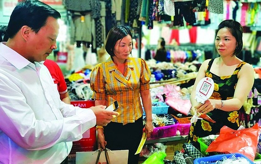 Cashless payment via digital applications is popular in Dai Tu Shopping Center in Thai Nguyen Province. (Photo: SGGP)
