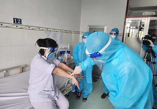 A representative of the General Department of Preventive Medicine visit the female patient. Photo: VNA
