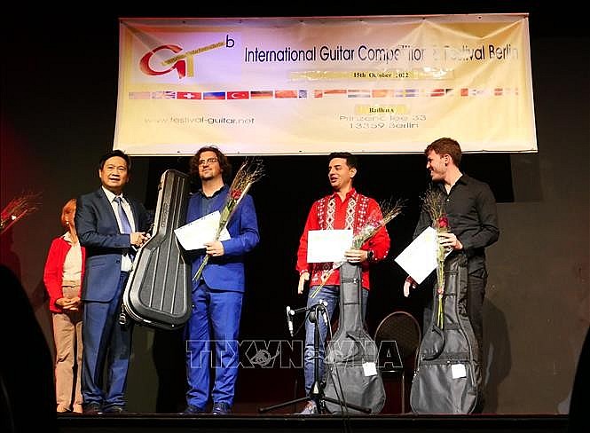 Professor and musician Dang Ngoc Long (left) awarded the first prize to the Italian contestant Luca Romanelli, the second prize to the Spanish contestant Samnuel Beluzan Rodriguez (red shirt) and the third prize contestant from Paraguay Raul Rolon. Photo: VNA