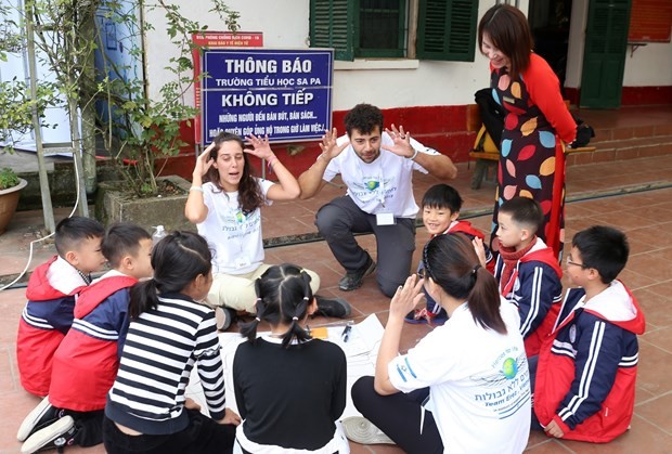 Israeli volunteers play games with local students. Photo: VNA