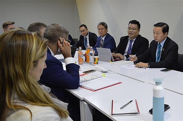 At the working session between Minister of Natural Resources and Environment Tran Hong Ha (R) and President for COP26 Alok Sharma. (Photo: VNA)