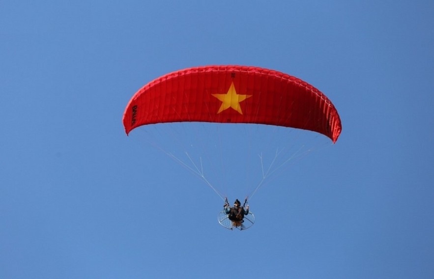 Paragliding over golden rice terrace fields in Northern Vietnam