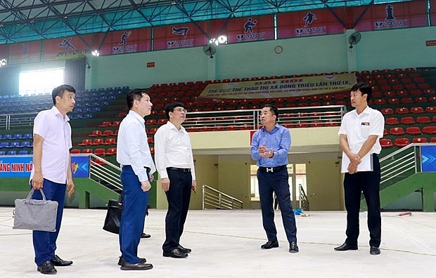 The inspection team checks the floor and lighting system of Dong Trieu Town Gymnasium to ensure it satisfies the requirements for badminton event. Photo: baoquangninh.com.vn