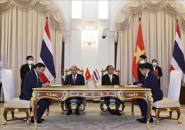 President Nguyen Xuan Phuc (sitting, left) and Prime Minister Prayut Chan-o-cha (sitting, right) witness the signing of the Memorandum of Understanding (MoU) on the Establishment of Sister City Relationship between and Thailand’s Khon Kaen province and Vietnam’s Da Nang city. Photo: VNA