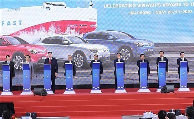 Prime Minister Pham Minh Chinh (C) and other delegates attend the ceremony to export the first batch of VinFast electronic vehicles to the US. Photo: VNA