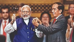 PM Modi holds the gavel as Indonesia’s President Joko Widodo hands over the G20 presidency.