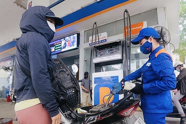 A customer refills her motorbike at a petrol station in Hanoi. Photo: VNA