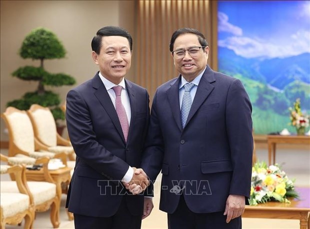 Prime Minister Pham Minh Chinh (R) receives Lao Deputy PM and Minister of Foreign Affairs Saleumxay Kommasith in Hanoi on December 7. Photo: VNA