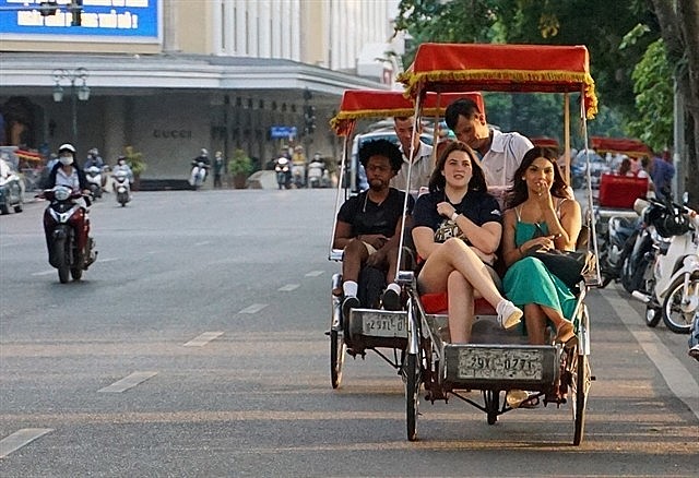 Foreign tourists on cyclo rides in the historic downtown district of Hoàn Kiếm, Hà Nội.  Photo: VNS