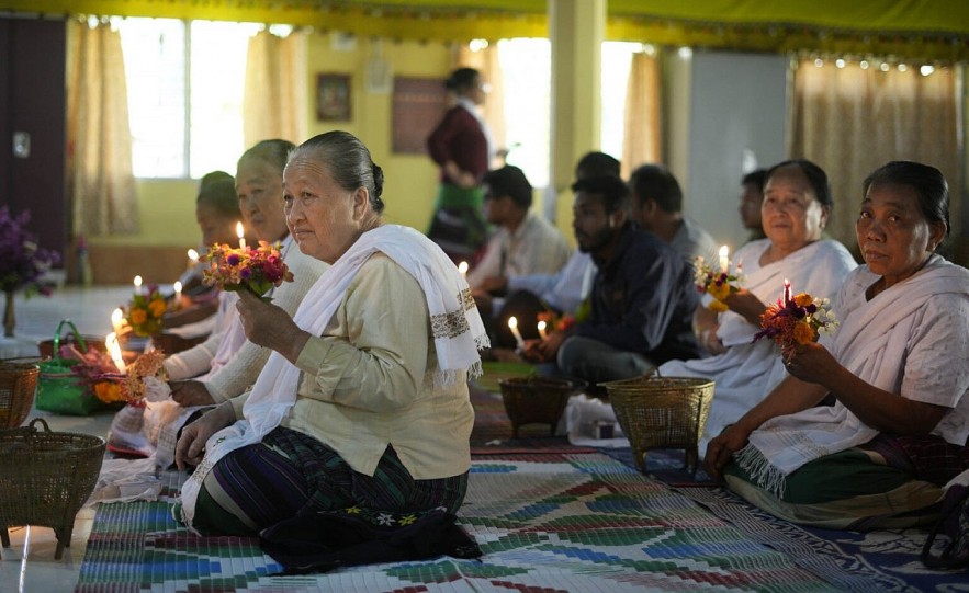 Villagers take part in a prayer at Namphake Buddhist Monastery