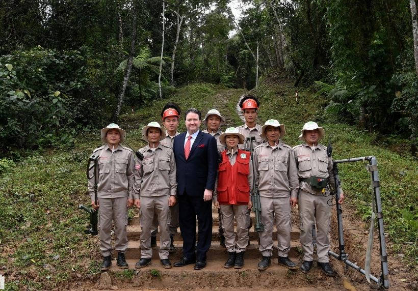 US Ambassador Marc Knapper took a commemorative photo with officials clearing mines and unexploded ordnance at the foot of A Bia hill. Source: Dan Tri