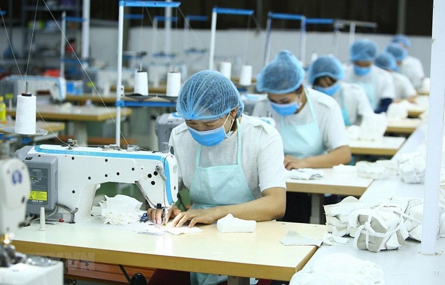 Local employees work at a clothing facility. (Photo: VNA)