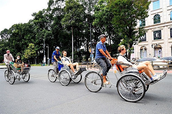 Foreign tourists sightsee in downtown HCM City in cyclos. Photo: VNA