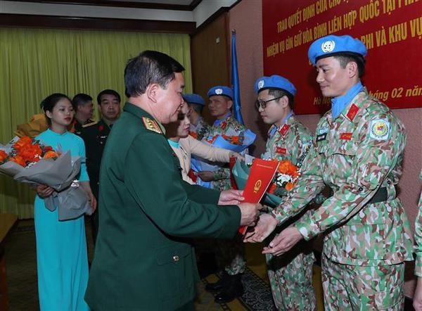 Sen. Lt. Gen. Hoang Xuan Chien hands over the decisions to the officers. Photo: VNA