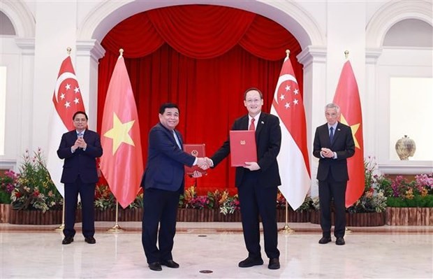The two Prime Ministers witness the signing and hand-over of the MoU on the establishment of the Vietnam - Singapore partnership on digital economy and green economy. Photo: VNA