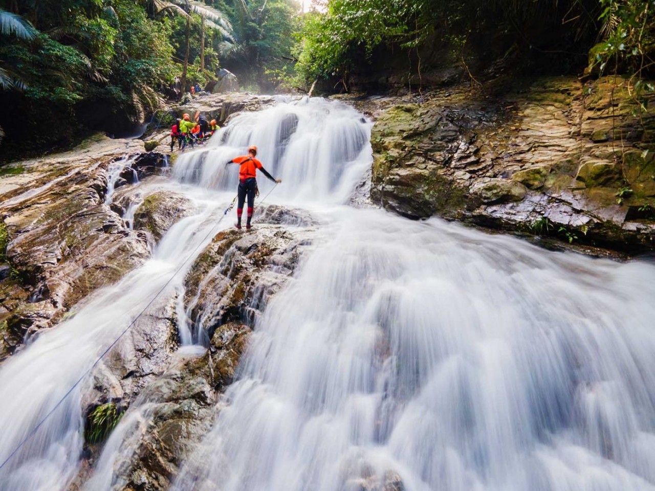 Visitors experience the adventurous rope swing over Duong Cam waterfall. Photo: Netin