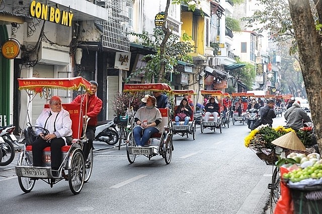 A group of foreign visitors go on sightseeing tour in Hà Nội's Old Quarter on xích lô (cycle rickshaw) in 2023. — VNA/VNS Photo Minh Quyết