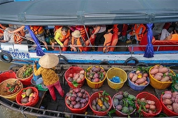 Tourist buy fruits at Cai Rang floating market in the Mekong Delta province of Can Tho. (Photo: VNA)