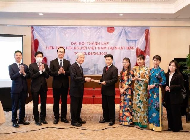 Nguyen Duc Minh, Interim Chargé d'affaires of the Vietnamese Embassy in Japan, presents the decision to recognise the union of Vietnamese associations in Japan by the Ministry of Foreign Affairs to Vo Cong Tanh, honorary president of the union.  Photo: VGP