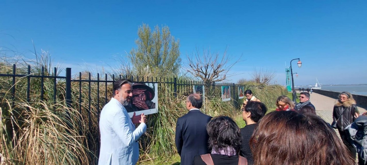 Impressionist photographer Réhahn introduces his works to audience at the exhibition. Photo: VNA