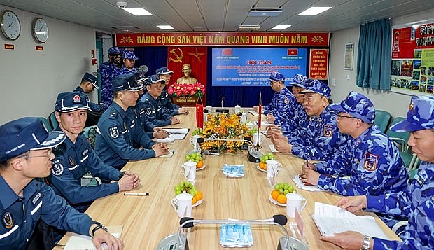 The coast guard forces of Vietnam and China hold talks on Vietnam's Coast Guard Vessel 8004 during the joint patrol. (Source: VNA)