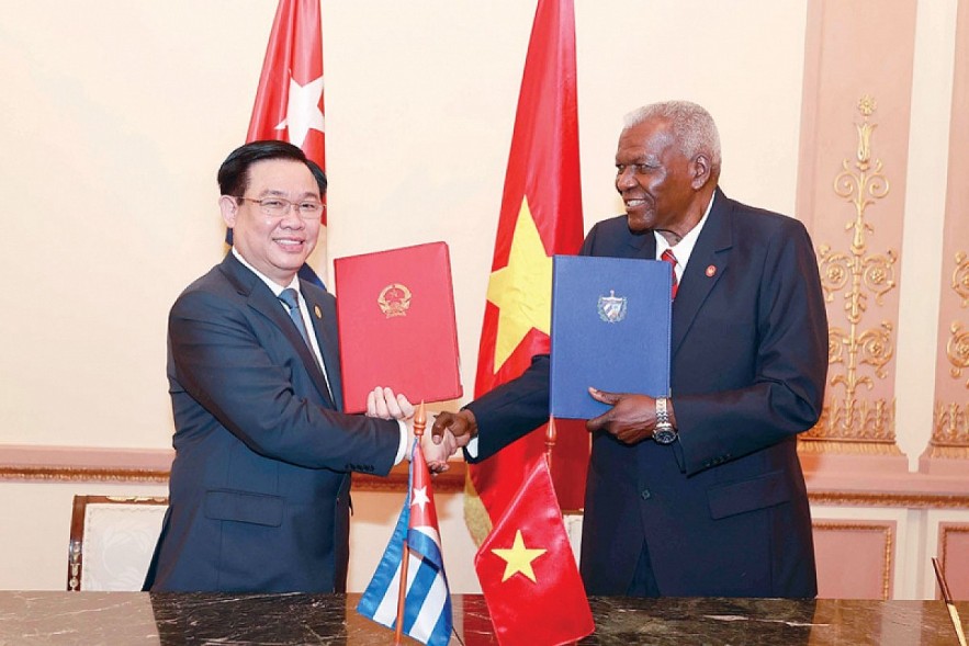 Esteban Lazo Hernandez (R), president of the National Assembly of People's Power of Cuba, and Vuong Dinh Hue, chairman of the National Assembly of Vietnam, exchange the signed cooperation document between the two legislatures. (Photo: daibieunhandan.vn)