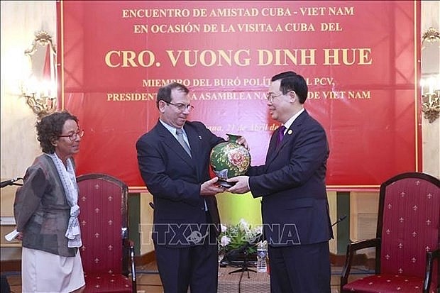 NA Chairman Vuong Dinh Hue (R) presents a souvenir to representatives of ICAP (Photo: VNA)
