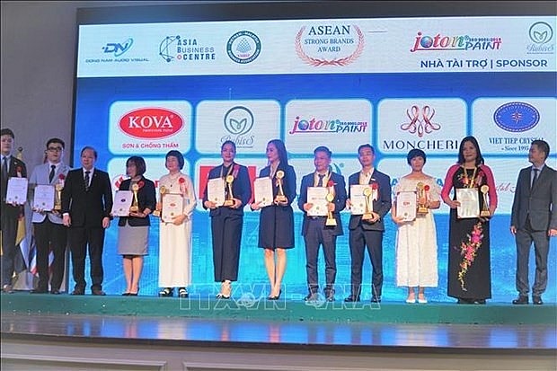 Le Gia Kien (first from right), Counselor at the Vietnamese Embassy in Malaysia, presents certificates recognising strong ASEAN brands to their winners at the ceremony. (Photo: VNA)