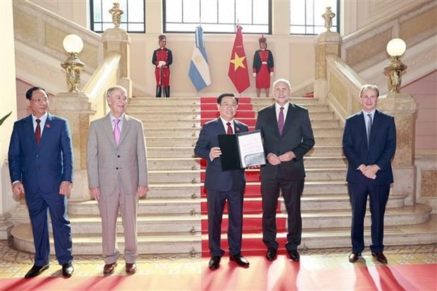 Governor of Santa Fe Omar Ángel Perotti (2nd from R) awards the title of Honorary Guest to National Assembly Chairman Vuong Dinh Hue. Photo: VNA
