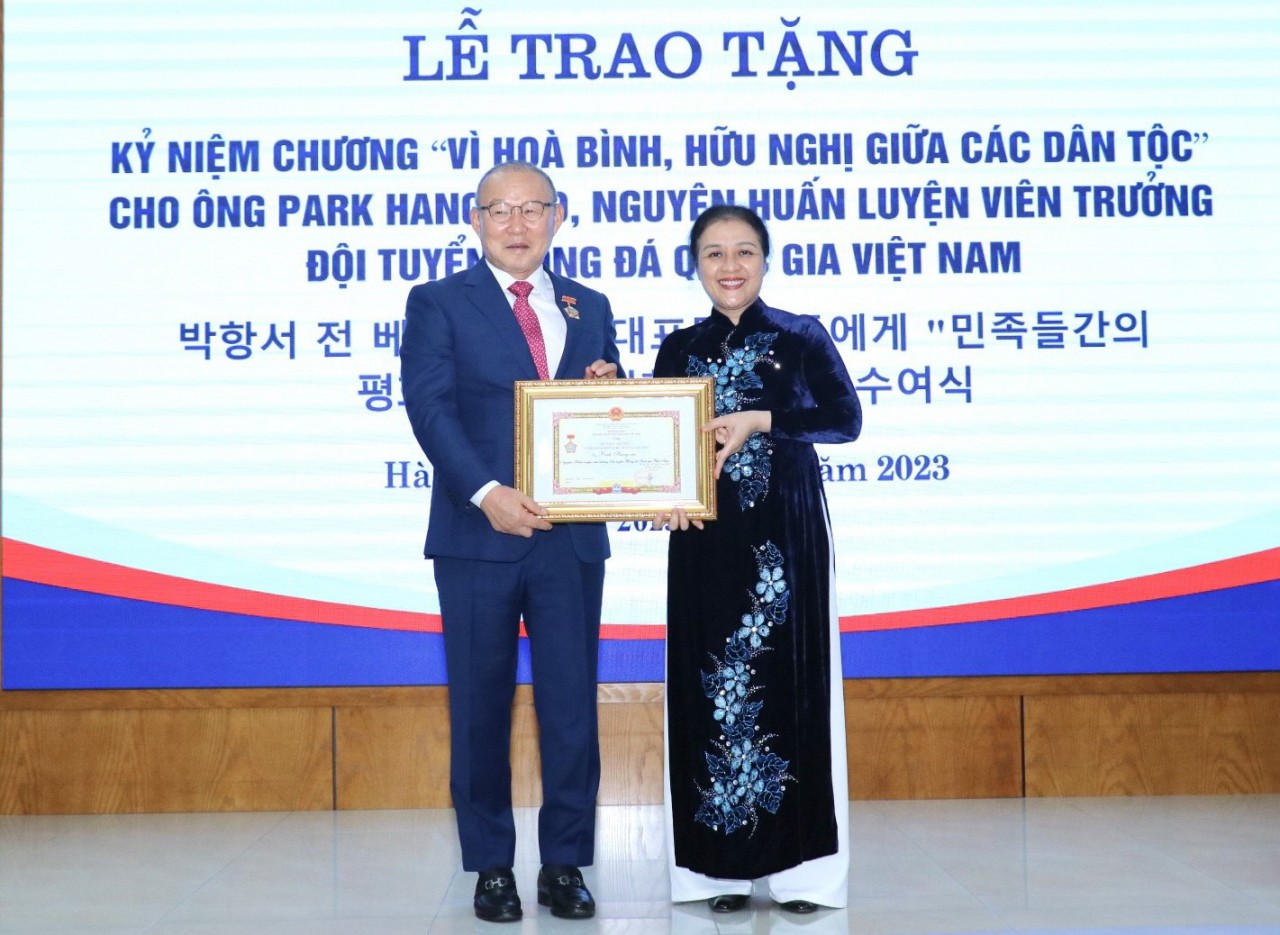 Ambassador Nguyen Phuong Nga (right) presents the insignia to coach Park Hang-seo. Photo: Thu Ha