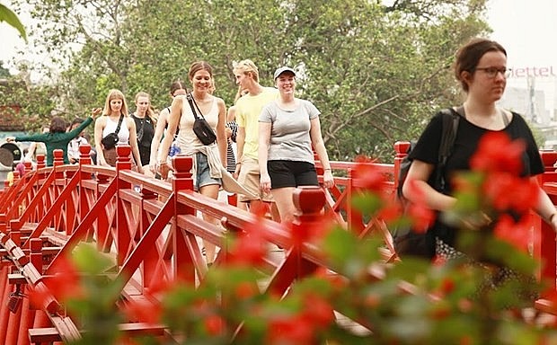Tourists visit The Huc bridge, Ngoc Son temple in Hanoi (Photo: VNA)