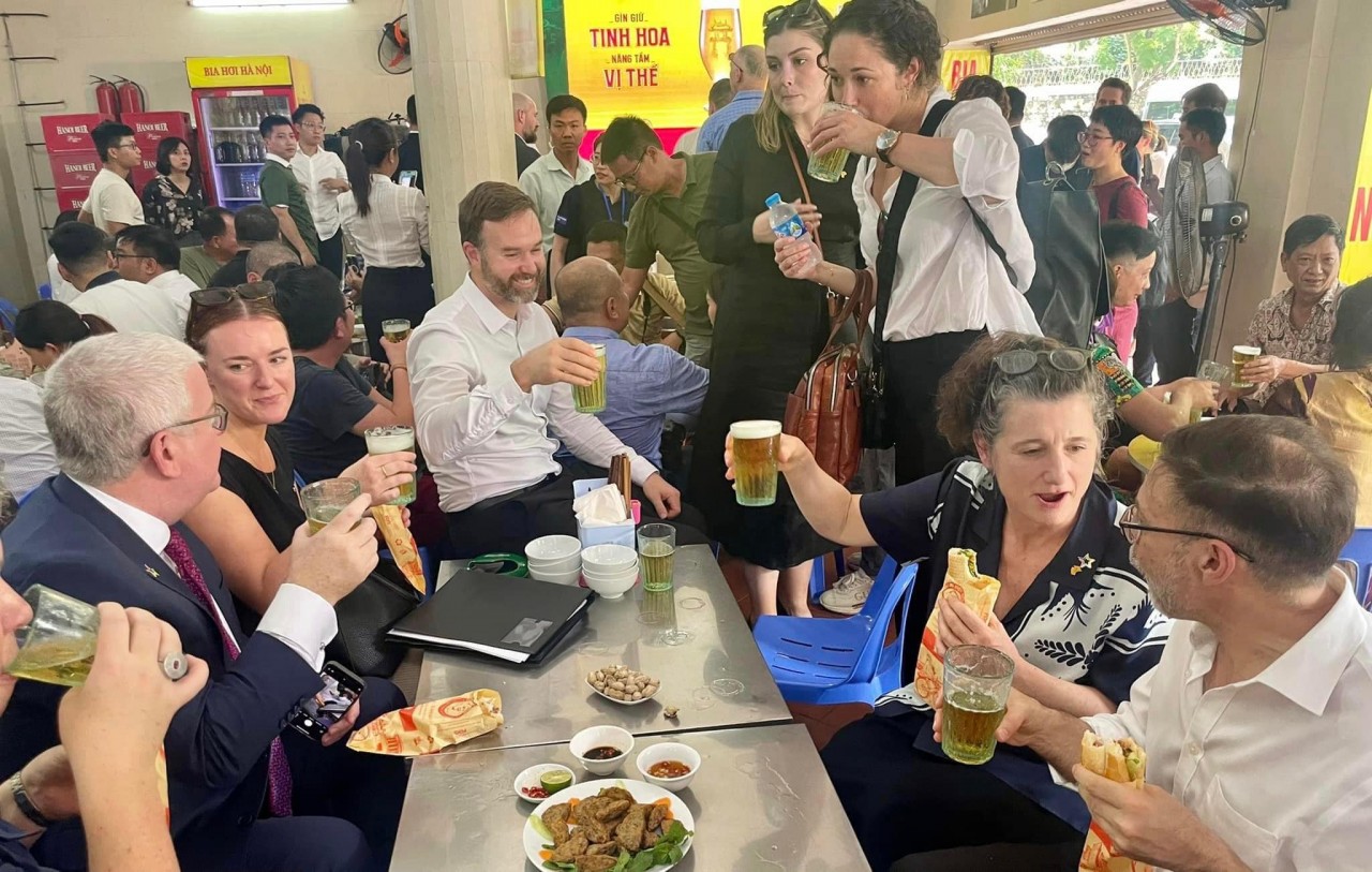 Australian officials sip locally brewed beer and eat banh mi. Photo: Thanh Nien newspaper