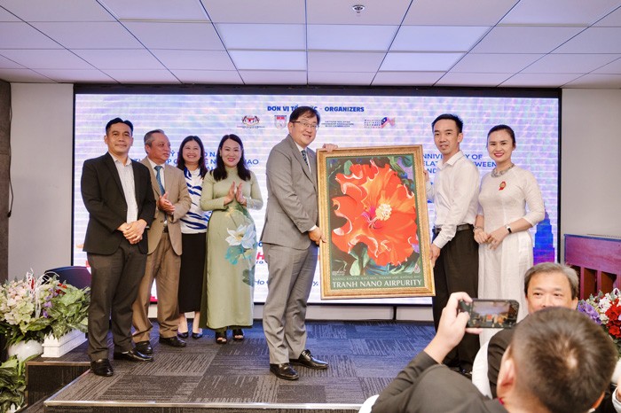 Representative of Vietnamese enterprises presents paintings to Malaysian Ambassador to Vietnam Dato Tan Yang Thai. Photo: VNA
