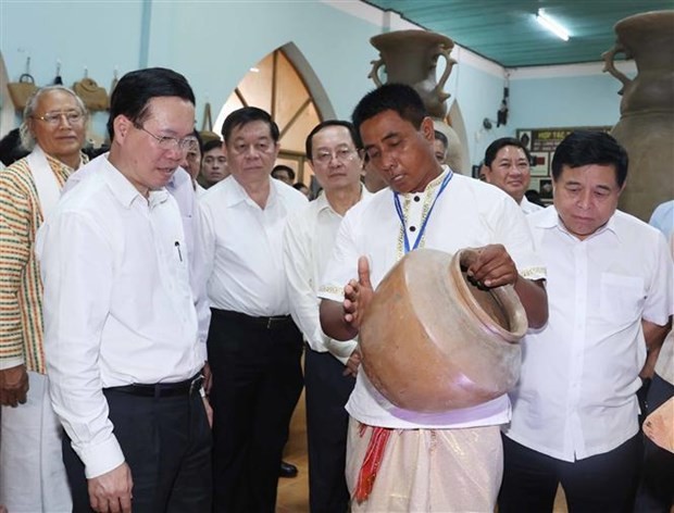 President Vo Van Thuong (left) visits an exhibition hall of pottery products in Bau Truc village on June 15. Photo: VNA
