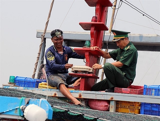 A boat owner and a border soldier inspect the vessel's journey monitoring system in the south-central province of Phú Yên. — VNA