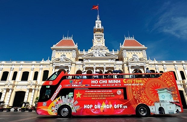 Tourists to Ho Chi Minh City take a city tour on a double-deck bus. (Photo: chinhphu.vn)